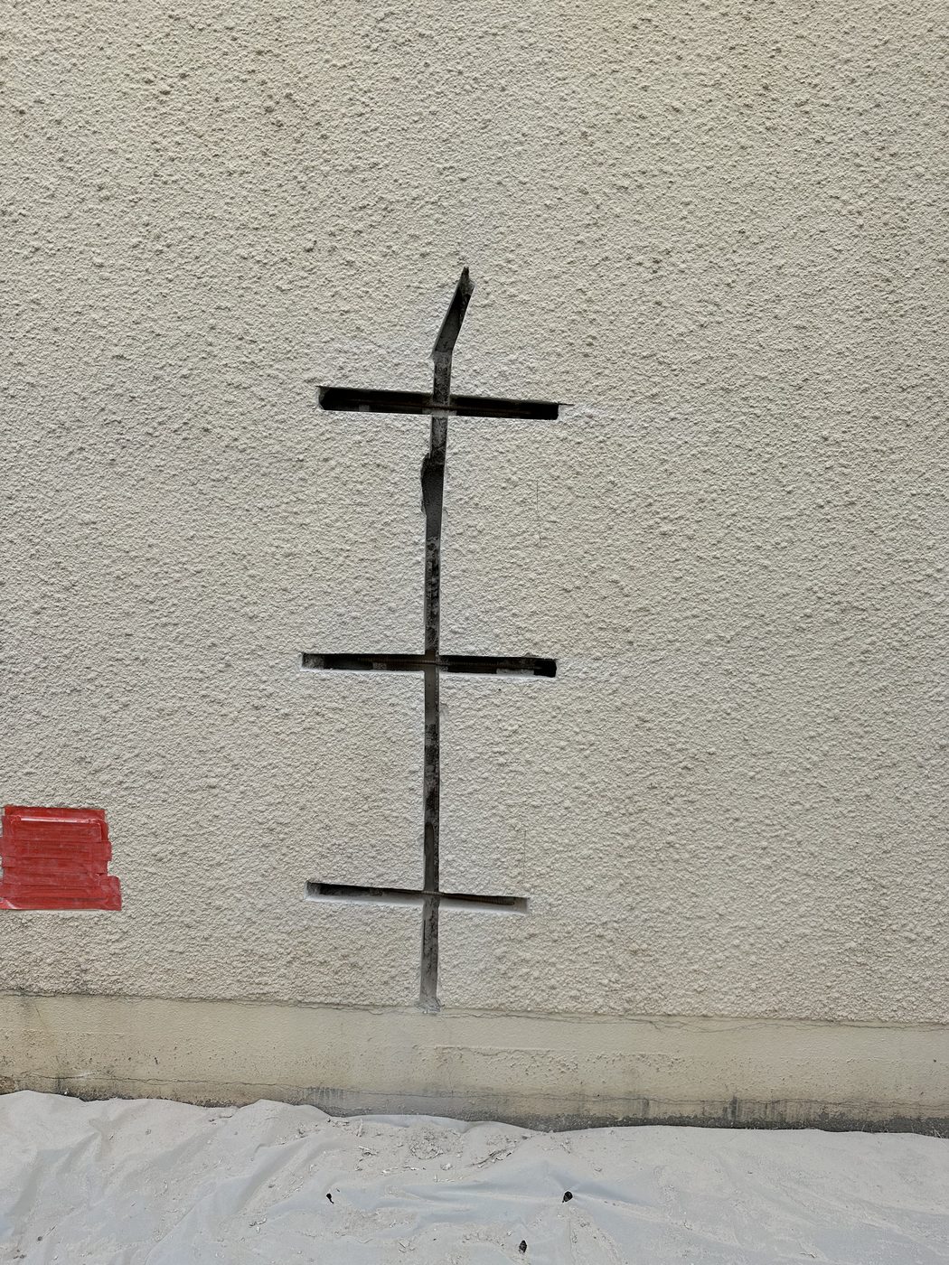 Fissure verticale profonde sur une façade — saignées creusées de part et d'autre, prêtes pour la pose des agrafes